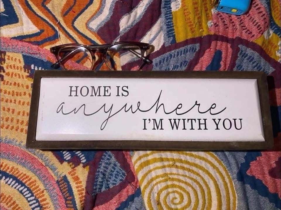 Hanging framed wooden sign that says “HOME IS anywhere I’M WITH YOU.”